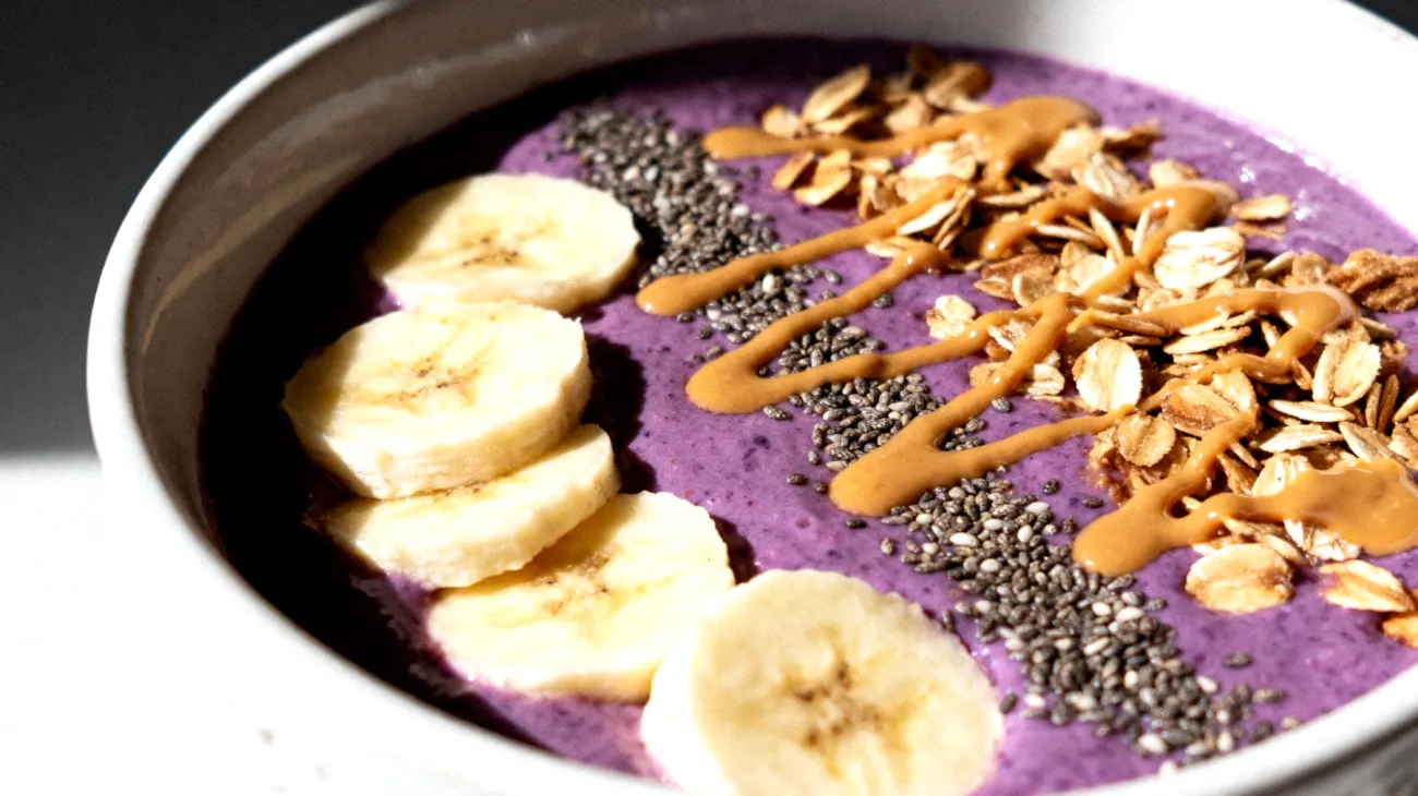 Smoothie bowl con semi di chia, banana, burro di mandorle e granola di avena"